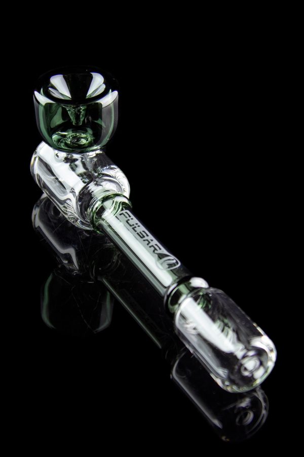 Clear glass cannabis oil rig with green accents, displayed on a reflective black surface.