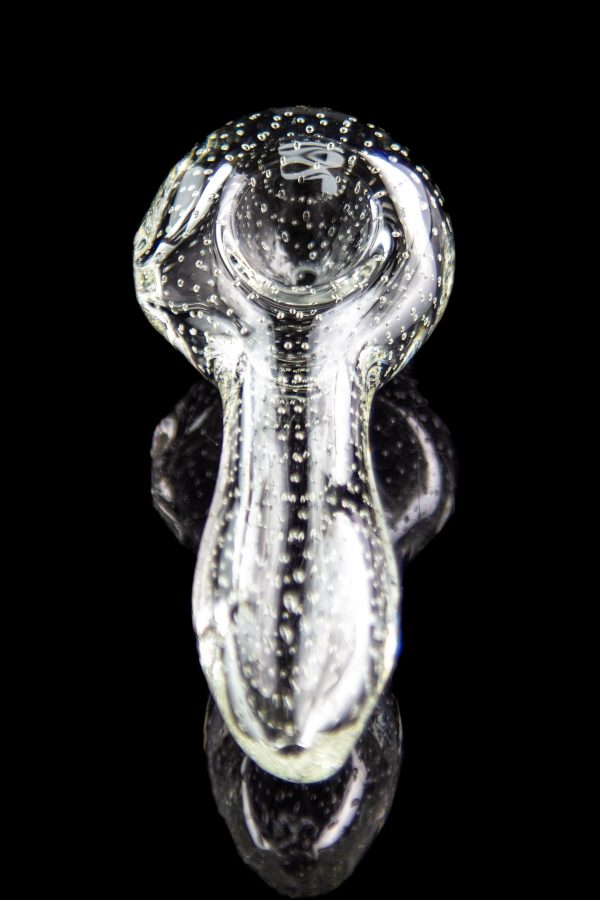 Clear glass bubbler pipe with speckled pattern, reflecting on a dark surface.