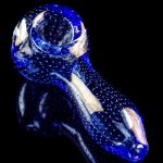 A side view of the Pulsar Bubble Matrix Spoon Pipe, showing a blue glass pipe with a speckled pattern against a black background.