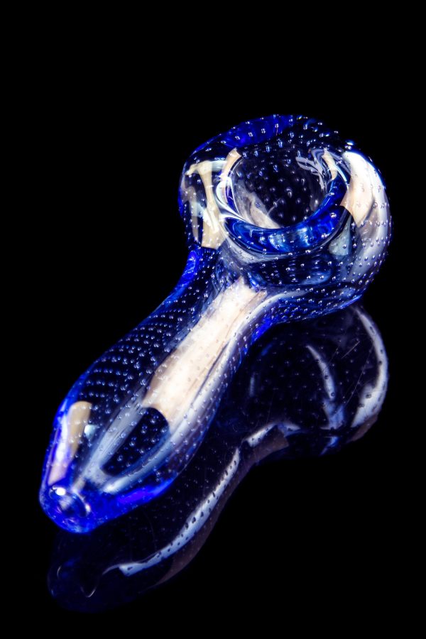 Blue glass pipe with white speckled accents, isolated on black.