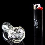 Glass cannabis pipe and lighter with branding, studio shot.