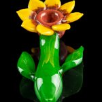 A vibrant green and yellow glass cannabis pipe shaped like a blooming flower.