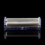 Sleek gold cannabis storage container encased in clear acrylic, with a mirrored reflection on a black surface.