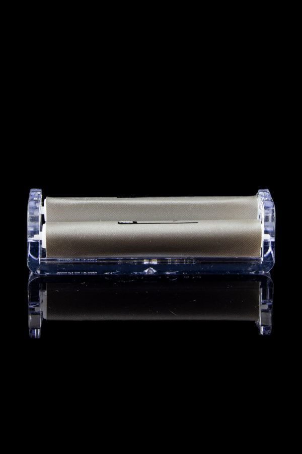 Sleek gold cannabis storage container encased in clear acrylic, with a mirrored reflection on a black surface.