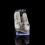 Clear acrylic container holding two pre-rolled cannabis cigarettes against a black background.