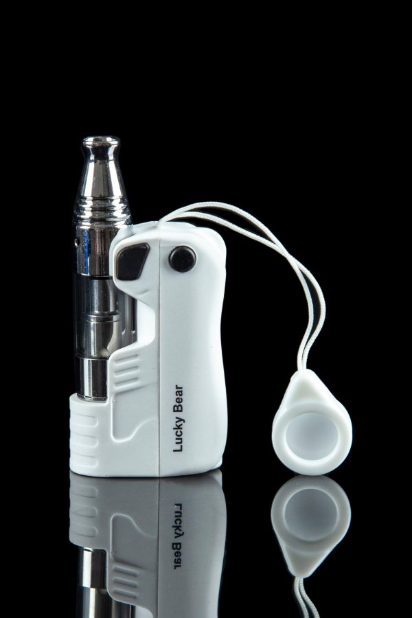 White cannabis oil vaporizer pen with glass cartridge and magnetic mouthpiece, reflected on a black surface.
