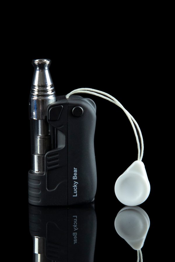Black cannabis vaporizer pen with a clear glass attachment and white silicone caps, reflecting on a glossy surface.