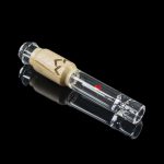 Clear glass smoking pipe with a wooden mouthpiece, reflecting on a black surface.