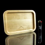 Wooden rolling tray with brand logo and lighter, reflected on a glossy black surface.