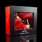 Red gift box with cannabis accessory inside, branded “Canada Puffin” with a reflective surface.