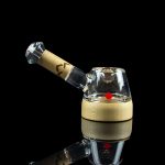 Glass cannabis dab rig with a wooden accent and reflective surface.