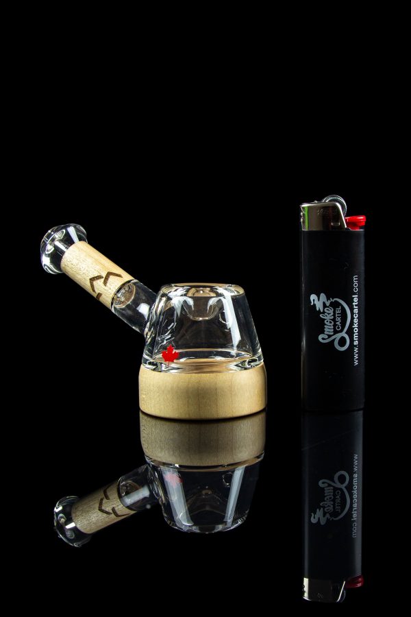 Glass bubbler water pipe and lighter on a reflective surface.