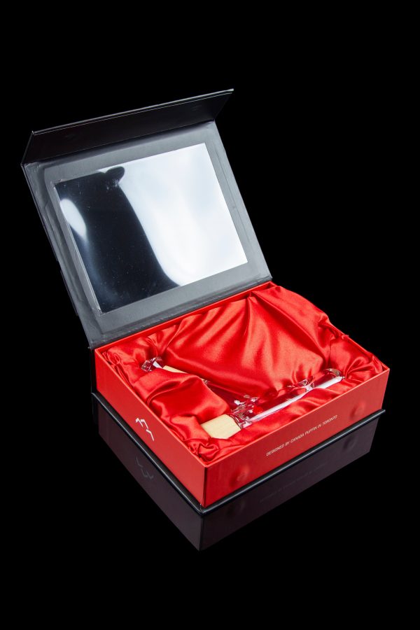 Luxurious red gift box with a clear window displaying cannabis accessories.