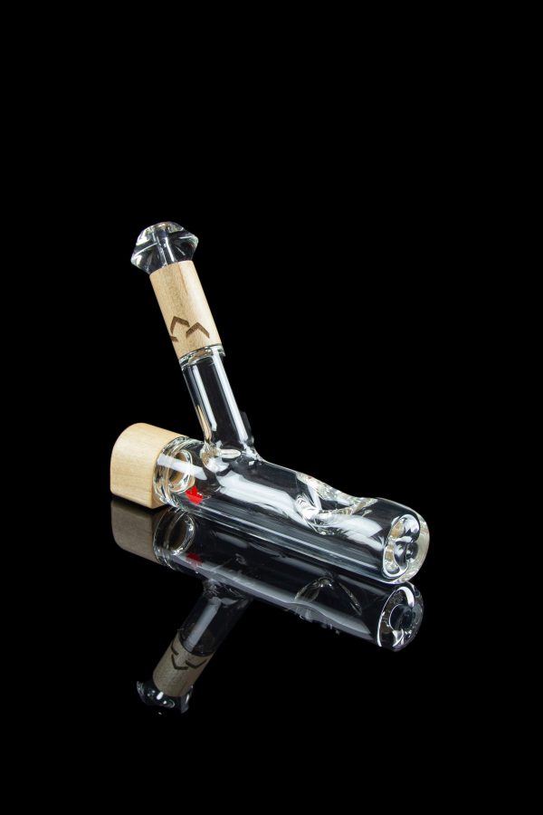 Glass bubbler with intricate internal design and cork accents, isolated on a black reflective surface.