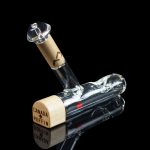 Glass bubbler with wooden accents and “Canada Puffin” text, reflected on a dark surface.