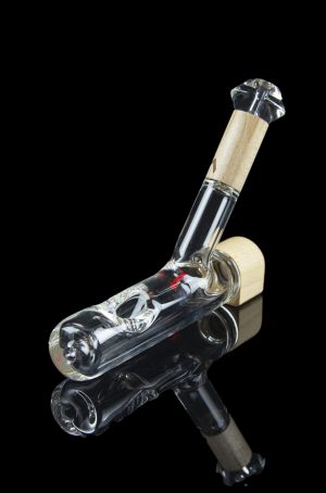 Glass bubbler pipe with intricate white and gray swirls, reflecting on a dark surface.