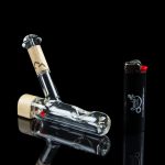 Glass bubbler water pipe and lighter on a dark background.