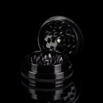 Black metal cannabis grinder disassembled, revealing tiered grinding components.
