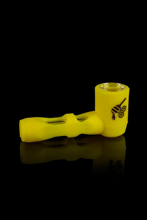 Yellow glass pipe with black branding, reflecting on a dark surface.