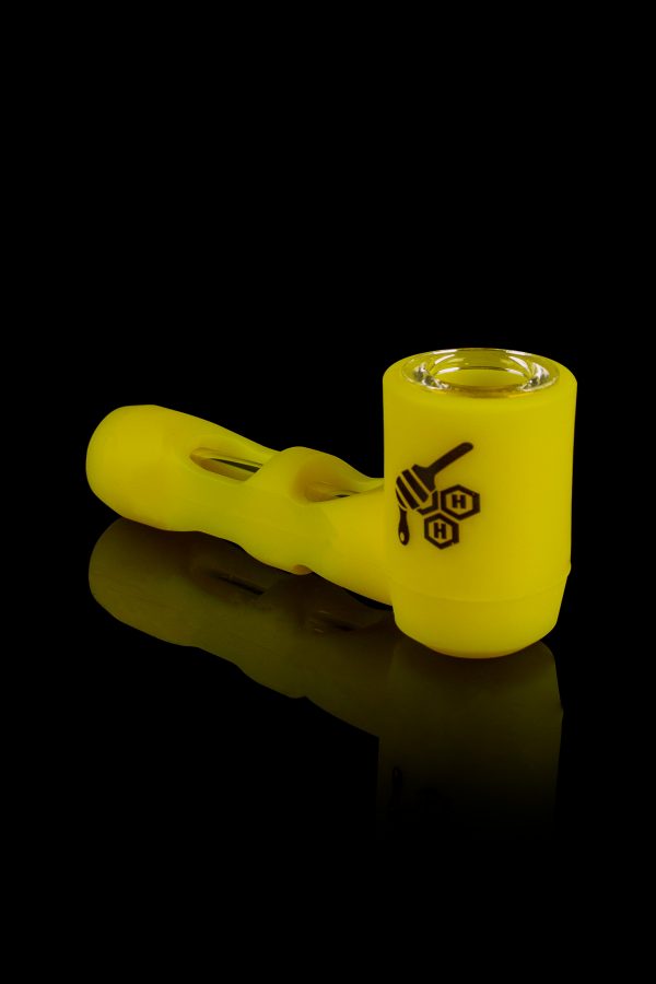 Yellow glass pipe with honeycomb logo against a black background.