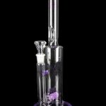 A clear glass water pipe (bong) with purple accents and intricate internal percolators, isolated on a black background.