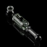 Glass cannabis oil rig with intricate bubbler design, isolated on a black background.