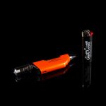 Orange and black cannabis vaping device with a lighter on a black background.