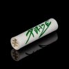 White cannabis filter tip with green handwritten text and floral design, reflecting on a black surface.