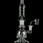 Clear glass water pipe (rig) with bubbler and quartz banger, isolated on a black background.