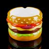 Glass pipe shaped like a colorful hamburger against a black background.