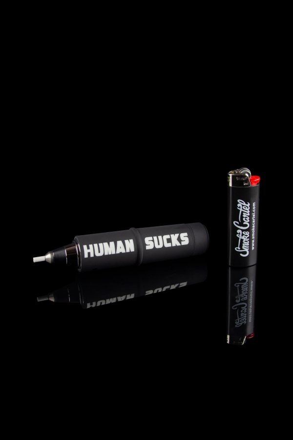 Black cannabis pipe and accessories with bold white and red text reading "HUMAN SUCKS" and a lighter beside it, against a black background.