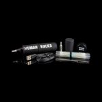 Cannabis vaping kit with pen, charger, and accessories on a black background, branded with “HUMAN SUCKS.”
