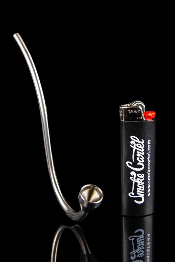 Silver glass pipe and lighter on a black reflective surface.