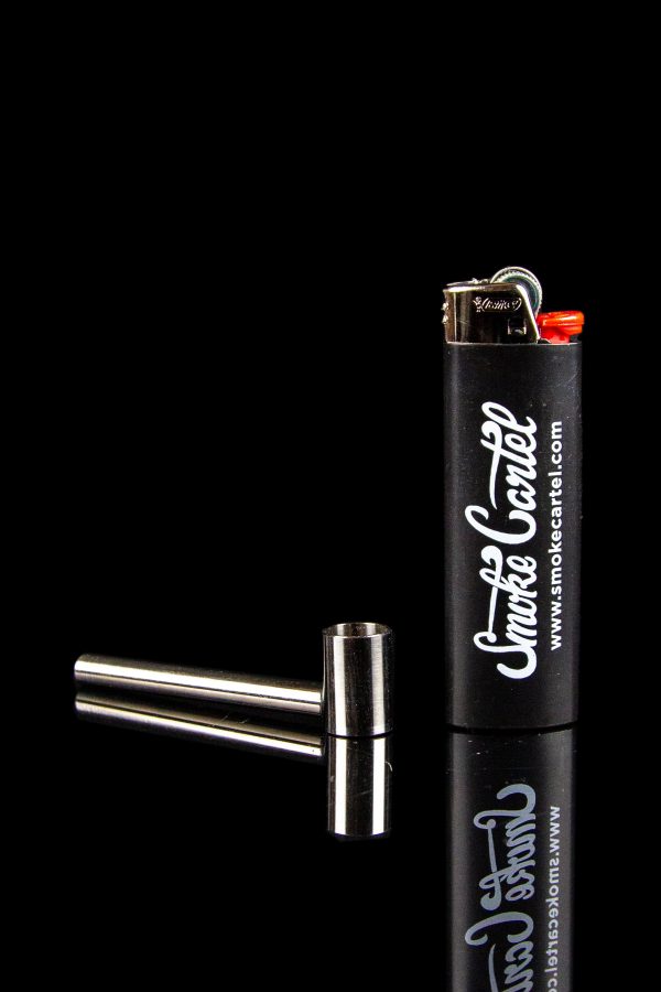 Black lighter and metal smoking pipe on a reflective surface, branded with "Smoke Cartel" logo.