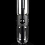 Sleek, black cannabis oil vaporizer (dab rig) with a glass chamber and illuminated heating element, displayed on a circular base.