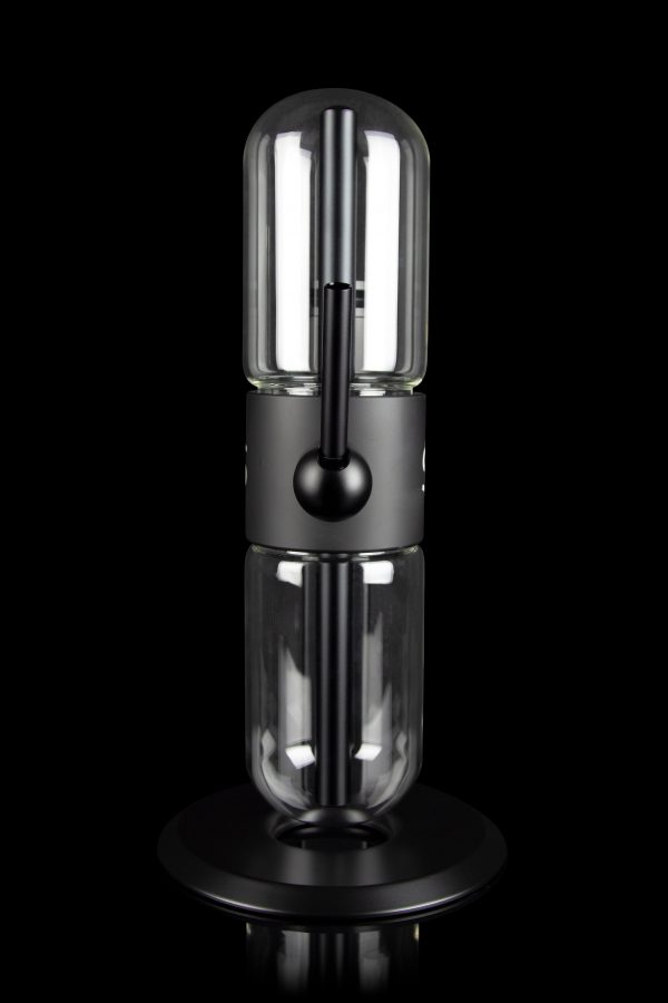 Sleek, black cannabis oil vaporizer (dab rig) with a glass chamber and illuminated heating element, displayed on a circular base.