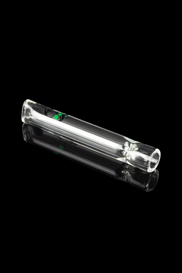 Clear glass smoking pipe with a leaf design, reflecting on a black surface.