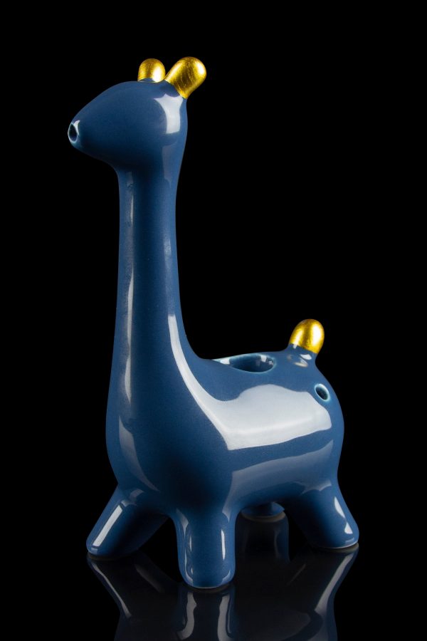 Blue ceramic giraffe-shaped water pipe with gold horns, reflecting on a black surface.