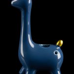 Blue giraffe-shaped glass pipe with gold accents, reflecting on a glossy black surface.