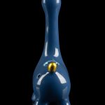 Blue glass water pipe shaped like a giraffe with gold accents, reflecting on a black surface.