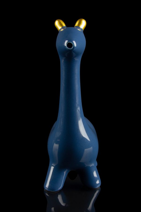 Blue glass water pipe shaped like a giraffe with gold horns, reflected on a black surface.