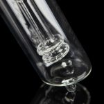 Close-up of a clear glass bong with intricate percolators against a black background.