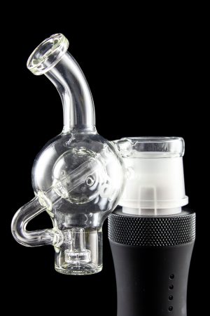 Clear glass water pipe (rig) with a skull-shaped bubbler attached to a black electronic heating device, isolated on a black background.