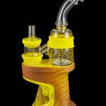 Yellow and wood-grain DabRig cannabis vaporizer with glass water pipe attachment.