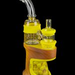 Orange electronic dab rig with glass bubbler and heating element, isolated on a black background.