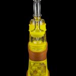 Yellow glass rig with intricate honeycomb detailing and clear mouthpiece, isolated on a black background.