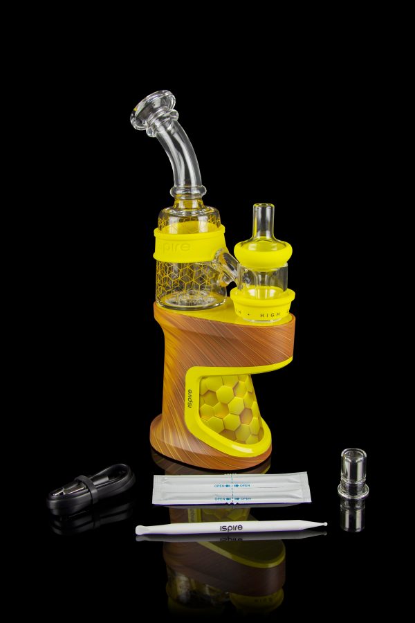 Yellow cannabis concentrate vaporizer (dab rig) with glass attachments and accessories on a reflective surface.
