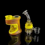 A portable electronic dab rig with a glass water pipe attachment and quartz banger, displayed on a reflective black surface.