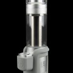 Silver cannabis vaporizer with a glass chamber and digital display, isolated on a black background.