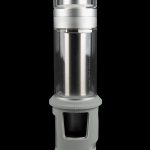 Silver cannabis water pipe with a cylindrical glass chamber and textured base, isolated on a black background.